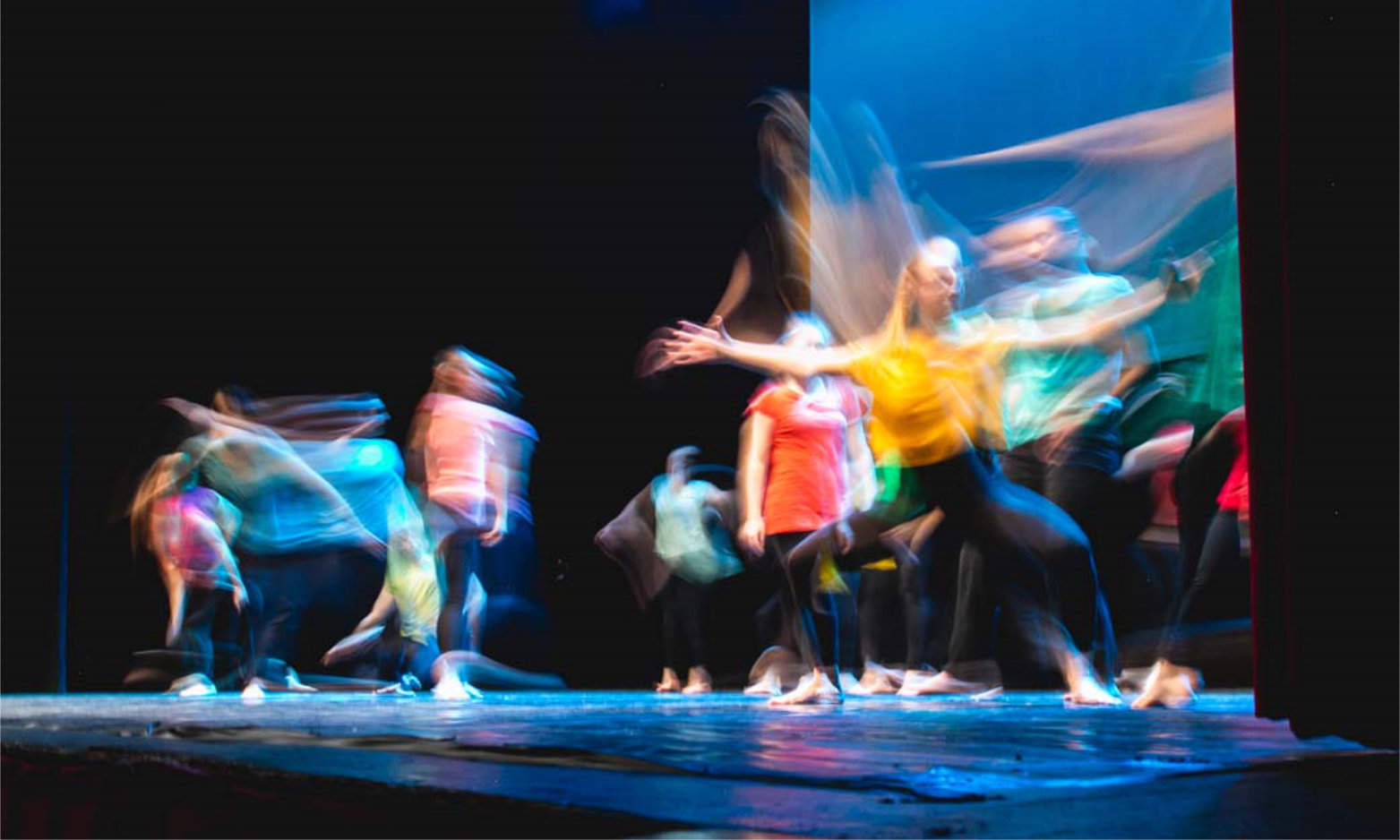 Group of dancer in colored clothes dancing on the stage in long